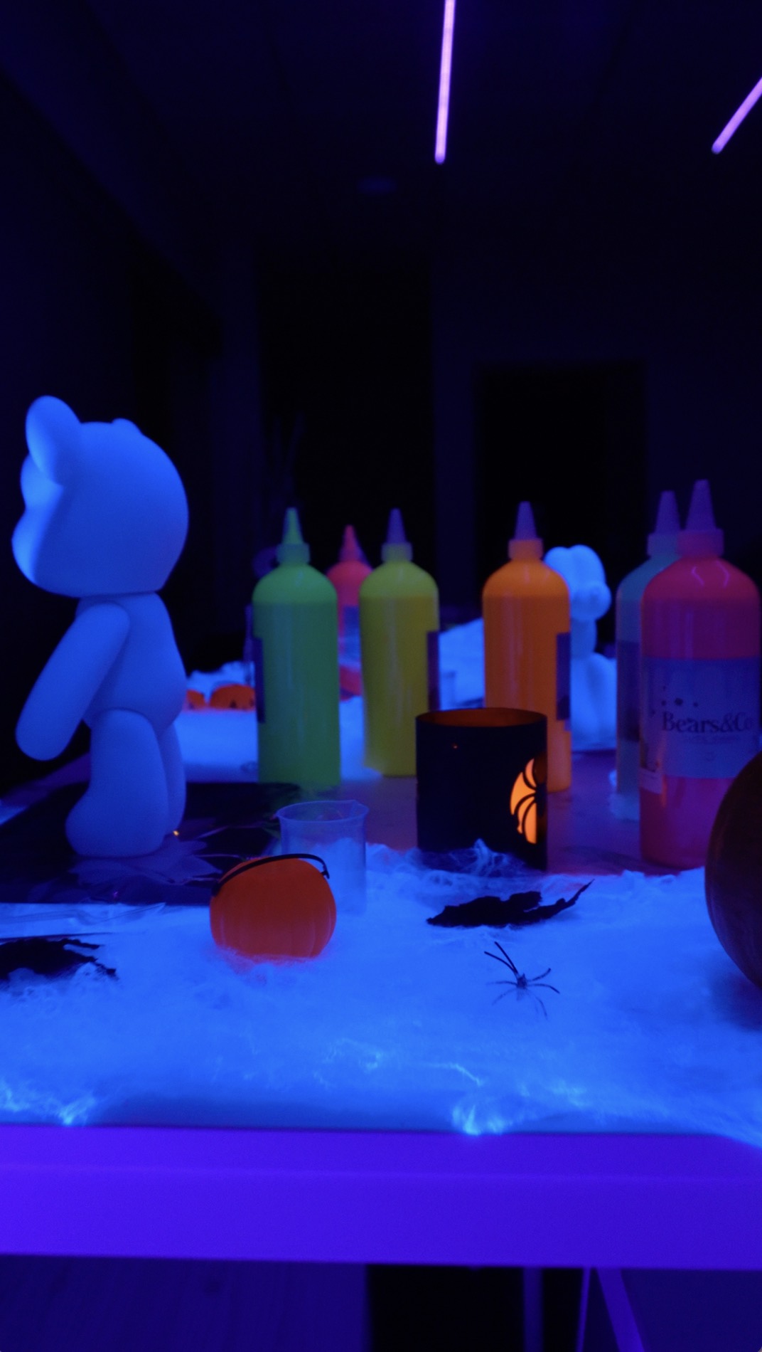 Mesa de pintura com tintas néon e decoração de Halloween